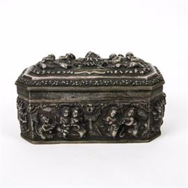 Burmese Repoussé Sterling Silver Box: A Burmese repoussé sterling silver box. The hinged box is octagonal in shape and is highly carved with Asian figures on bent knee with folded hands or holding objects. The box is further adorned with trees, outlines of buildings, and leaf motif. The total weight of the item is 44.50 ozt. This pieces scanned as sterling using an XRF machine.