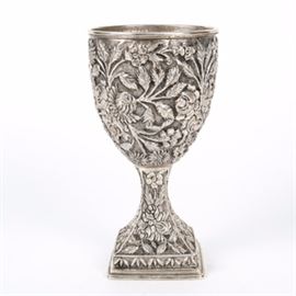 Sterling Silver Baltimore Rose Pattern Chalice: A large sterling silver goblet in the Baltimore rose pattern. The repousse square base goblet features a floral and vine leaf motif continually throughout. The square base is hollow and stamped in the center. The total approximate weight is 11.170 ozt.