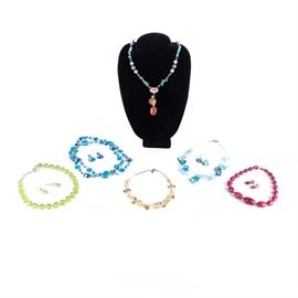 Assorted Beaded Costume Jewelry Demi Parure Sets: A beaded costume necklace assortment. This grouping includes four demi-parure sets of necklaces and earrings featuring glass beads and colored crystals. Along with two necklaces fashioned of glass beads, stones and silver tone metals. Hallmarks include “925” to one clasp.