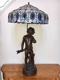 Contemporary bronze figural lamp of boy with blue Tiffany- style shade	