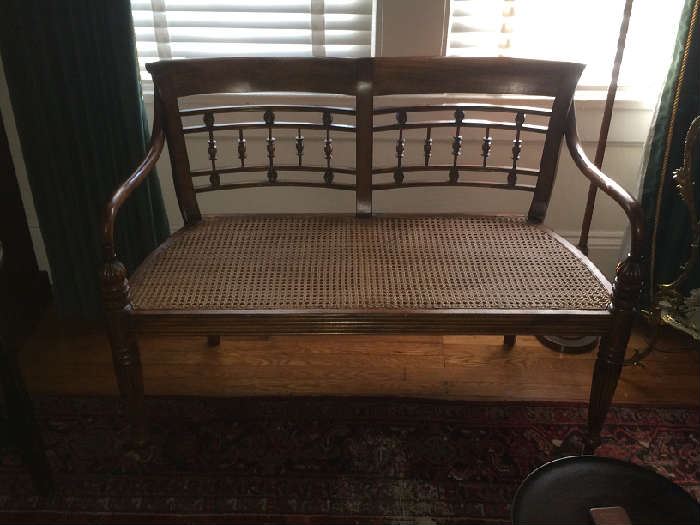 Reproduction 19th century carved and caned settee perfect for a tete a tete.  Excellent condition.