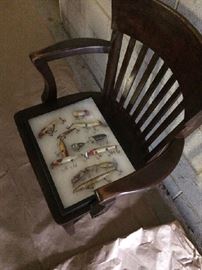 Vintage fishing lures offered in one tray, displayed on rock solid old fashioned office/jury chair