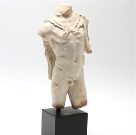 Reproduction Male Torso Sculpture: A male torso sculpture. This plaster reproduction of a male torso sculpture depicts a male form wearing a cape. The piece is unmarked and sits on a resin base.