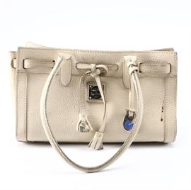 Dooney and Bourke Leather Handbag: A Dooney and Bourke leather handbag. The piece is cream in color with a rectangular structure and handles along either side. It offers an ornamental pull string to one side with silver tone metal hardware with a zipper compartment along the interior. It is numerically marked J6212672.