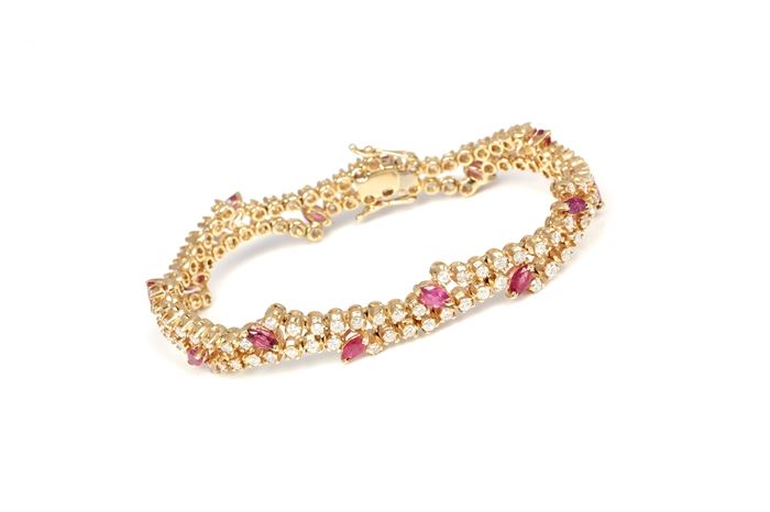 14K Yellow Gold 2.25 CTW Diamond and Ruby Bracelet: A yellow gold bracelet comprised of offset bands of round cut prong set diamonds and faceted marquise cut ruby accents.