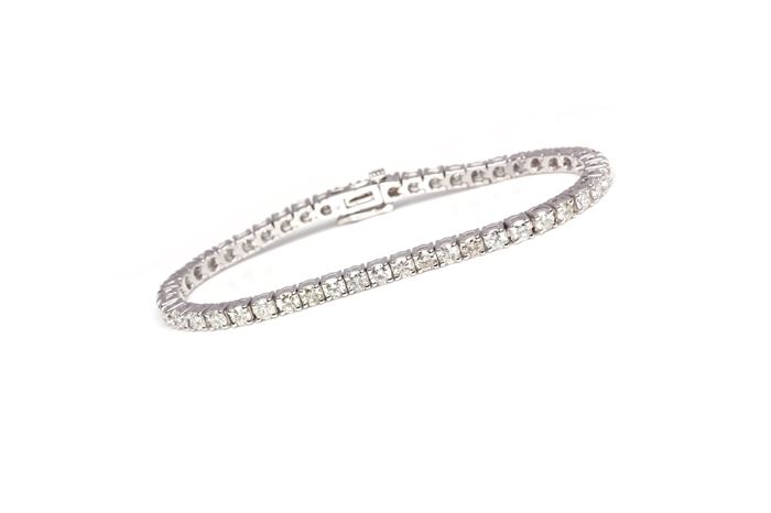 14K White Gold 6.04 CTW Diamond Bracelet: A white gold line bracelet with round cut basket prong set diamonds mounted side by side. The bracelet is in excellent condition and has never been worn.