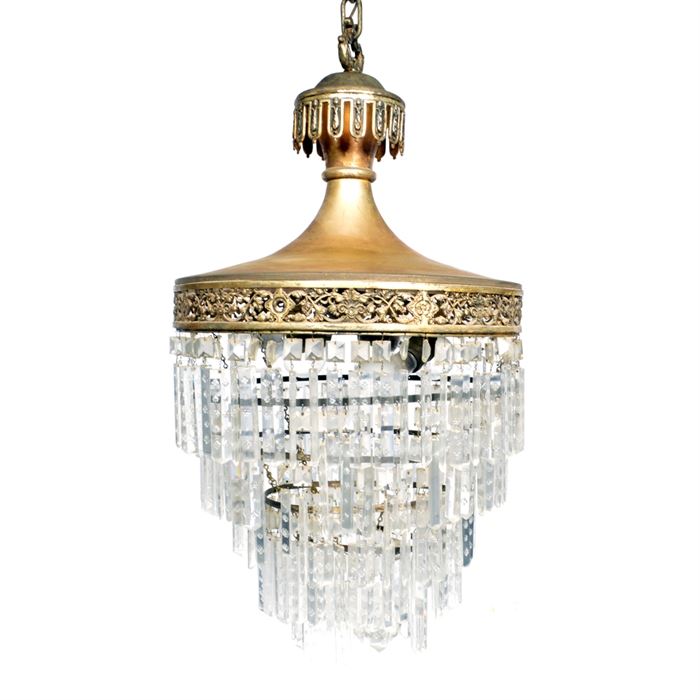 Vintage Chandelier With Crystal Prisms: A vintage chandelier with crystal prisms. This selection features five row of prisms supported by an ornate, brass tone top. It includes four light sockets and bears no visible maker’s marks.