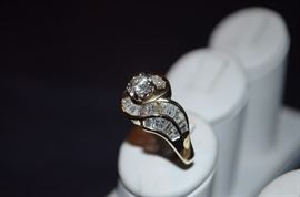 #2 Lovely Diamond Engagement Ring Ladies 14k yellow gold Bypass Style Engagement Ring mounting weighing 5.88dwt and is set in center with 1 Round Brilliant Cut Diamond approx. 50/100ct. The color is I the Clarity is I. Ring is channel set on sides and around center with 52 tapered baquette cut diamonds totaling approx. 2ct. The Color is G-H and the color is I -I. Total approx weight of all Diamonds is 2.5ct.