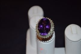 #6. Gorgeous Ameythyst & Diamond Ring Ladies 14k yellow gold Oval Style Ring Mounting weighing approx. 10.83dwt and is set in center with one Oval Cut Amethyst measuring approx. 23.2mm in length by approx. 17mm in width by approx. 12.3mm in depth and weighs approx. 26.45ct. Set around the center is 32 Round Brilliant Diamonds totaling 96/100ct. the color is H-J and clarity is SI(1) - SI(2) Total approx. weight of all Diamonds is 2.58ct