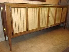 Mid century, solid walnut side board: Formica/laminate door inserts, shelves and drawers behind two triple bi-fold doors, custom beveled mirror top.  78" w, 18"d, 33" h
