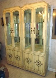 Two solid wood, china/curio cabinets, with a French Country feel.  Glass doors, sides and shelves, mirrored back, lighted, double door bottom storage area.  29-1/2" w, 15-1/2" d, 80" h.  Made in USA.
