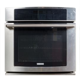 Electrolux Oven: An Electrolux oven. This stainless steel single oven has a natural gas source. The blue interior features eight shelving slots and two metal racks. The appliance was powered on but not tested.
