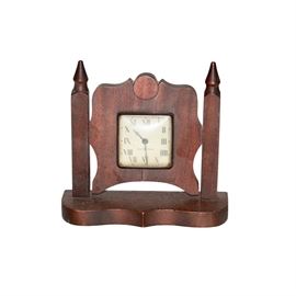 Circa 1915 True Time Tellers Mantel Clock: A circa 1915 wooden clock marked “True Time Tellers.” This clock features two pointed finials flanking the curved center. A square clock face is present to the center, marked “True Time Tellers.” It sits on a base with a straight back and serpentine front.