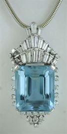 Lot 17: Stunning aquamarine and diamond Deco style pendant/pin set in platinum w/approx. 67 ct and approx. 6.0 ct tw tapered baguette's and round brilliant cut diamonds, 2.5” x 1.25”, 33.8 grams including a 14kt white gold 2 mm snake chain, 15” long, 14.1 grams