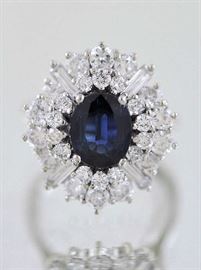 Lot 24: Blue sapphire and diamond cluster ring (tested) 18kt white gold set w/approx. 1.50 ct dark blue oval sapphire, slightly included and approx. 2.5 ct tw full and baguette cut diamonds, size 5.5, 6.8 grams