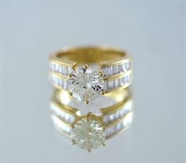 Lot 194: 18k yellow gold and diamond ring with a 2.02 ct round diamond with 24 baguette diamonds 1.20 ctw size 6.5