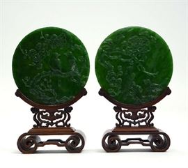Lot 216: Pair of green spinach jade round plaques, carved double sided floral/ birds 7.5" Dia. on rosewood stands, 12"H.