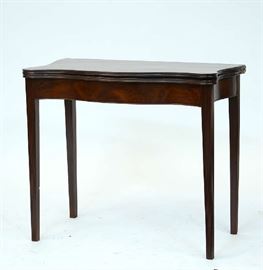 Lot 308: Early 19th C. serpentine front card table in mahogany with shaped top on fluted legs, 34"L.