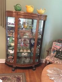 This oak curio cabinet is so beautiful.  With its' curved glass on sides and doors, glass shelves and antique mirror to show off you collection... it's the one you've been looking for!