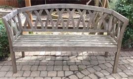 Smith and Hawken three person teak bench. 63in long x 22.75in deep x 33in high. Solid construction. Currently weathered with silver patina, can shine with a scrub and stain. Coordinates with bench in lot number 103.