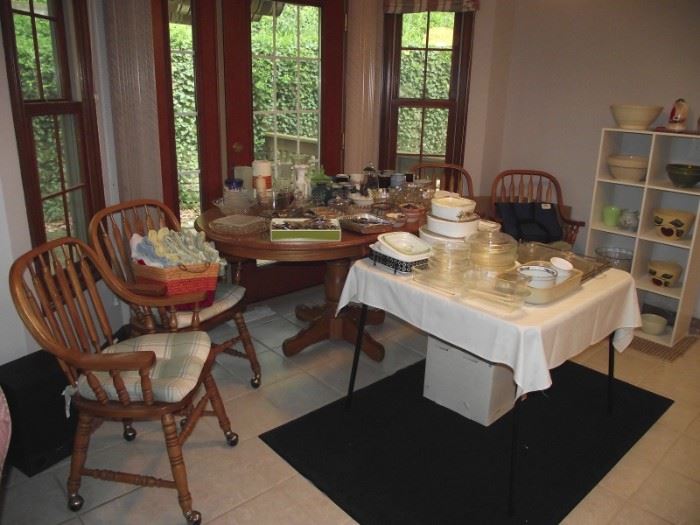 Oak kitchen table with four chairs on casters and all kinds of kitchen ware