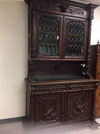 Carved court cupboard with stained glass.