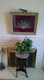 fan in a shadow box, plant and plant stand  