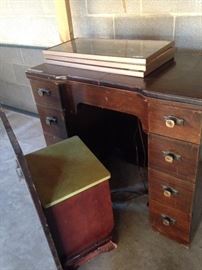 Very old sewing machine with chair that fits into the machine