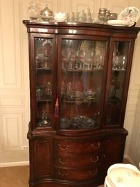 A beautiful vintage well made mahogany China cabinet holds many pieces of fostoria and cut glass.