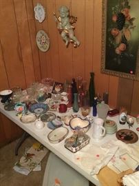 Check out the large cherub residing over a table full of vintage items. Lots of linen that is embroidered as well as great dresser items and China pieces.