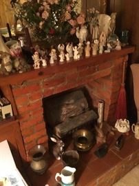 An angel collection on the mantle in the den with great old fireplace accessories