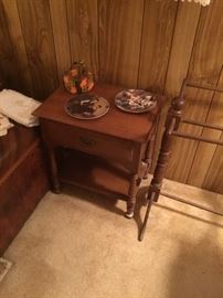 Neat side table with Norman Rockwell plates and a handmade quilt rack.