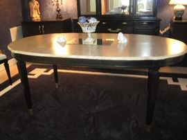 Oval dining room table with black painted base and natural wood top.  An extra leaf available.