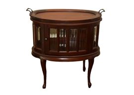 Oval TeaTable and Display Cabinet by Arhaus Furniture: An oval tea table and display cabinet, by Arhaus (Louise Tea Table), with a mahogany finish. The tray top with cast handles is removable. Below is a display cabinet or vitrine with beveled glass panes and an access door, on cabriole legs.