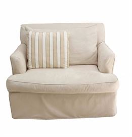 Ethan Allen Oversized Chair: An Ethan Allen oversized chair. This chair features an ivory upholstered cover with back pillow and skirted front. Also included is a beige and white square accent pillow.