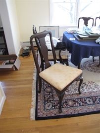 A close up view of the dining room queen-anne style chairs in a mahogany fnish