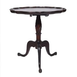 Early 20th C. Chippendale Style Tea Table: An early 20th century Chippendale style tea table. This table features a round top with a serpentine edge and sits on an acanthus carved pedestal, which terminates in splayed legs with claw-and-ball feet. It is finished in a mahogany stain.