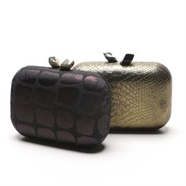 Clutches by Kotur: A grouping of Kotur clutches. This selection includes two clutches, featuring one gold tone with a faux snakeskin motif and a black and deep purple clutch. They each showcase brand markings to the hardware, and printed linings.