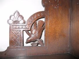 Carved birds on each side of corner shelf unit