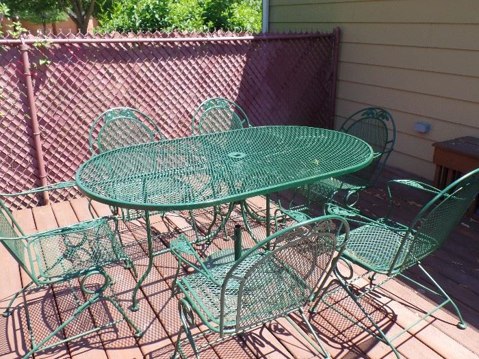 7pc green wrought iron patio set. All chairs are rockers - also has 2 matching lounge chairs, 2 side tables 7 umbrella stand 