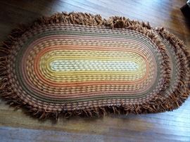 three identical braided rugs in orange and yellow