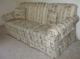 Couch with two accent pillows and arm covers.