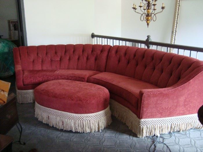 Custom upholstered curved two piece sectional with matching round automan