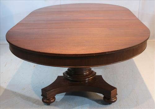 41 - Mahogany Empire dining table with column base, bun feet and 4 leaves with 2 skirted, 2 not skirted, 29 in. T, 88 in. L, 52 in. W.
