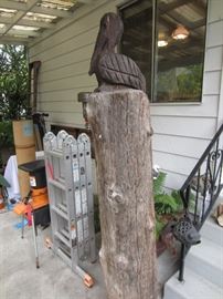 Totem-style carved pelican on post