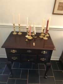 Server with collection of brass candlesticks