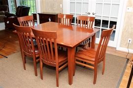 Handcrafted Amish Furniture Dining Table and Chairs: A Handcrafted Amish Furniture dining table and chairs set. This cherry wood set features two leafs within for self-store and six identical Venice side chairs. The rectangular surface features a beveled edge and no radius. Table features four shaker legs.