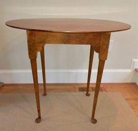 Elegant oval top tea table overhanging straight apron with simple turned and tapered legs terminating in turned pad feet. Wonderful, smooth finish!