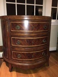 Elegant demi-lune, flame mahogany silver chest with marquetry accents.