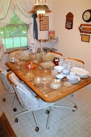 Kitchen table with 5 rolling chairs, glassware and dishes